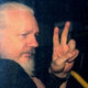 WikiLeaks founder Julian Assange gestures to photographers from a police vehicle while arriving at Westminster Magistrates court in April 2019 in London, England.